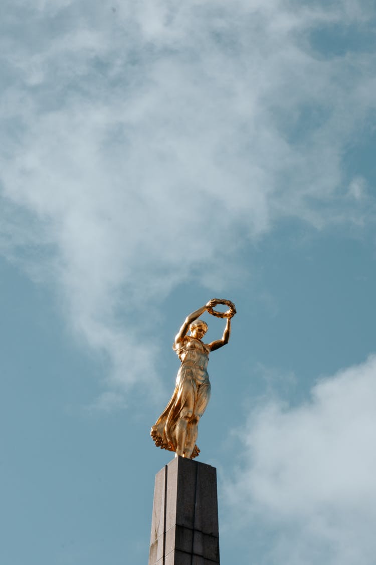 Golden Statues On Blue Sky Background