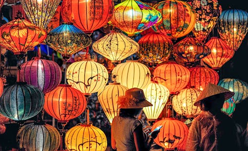 Two Person Standing Near Assorted-color Paper Lanterns