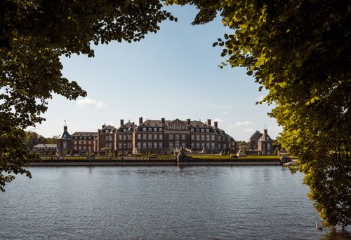 Free Scenic view of Nordkirchen Castle framed by nature and reflected in a serene waterfront. Stock Photo