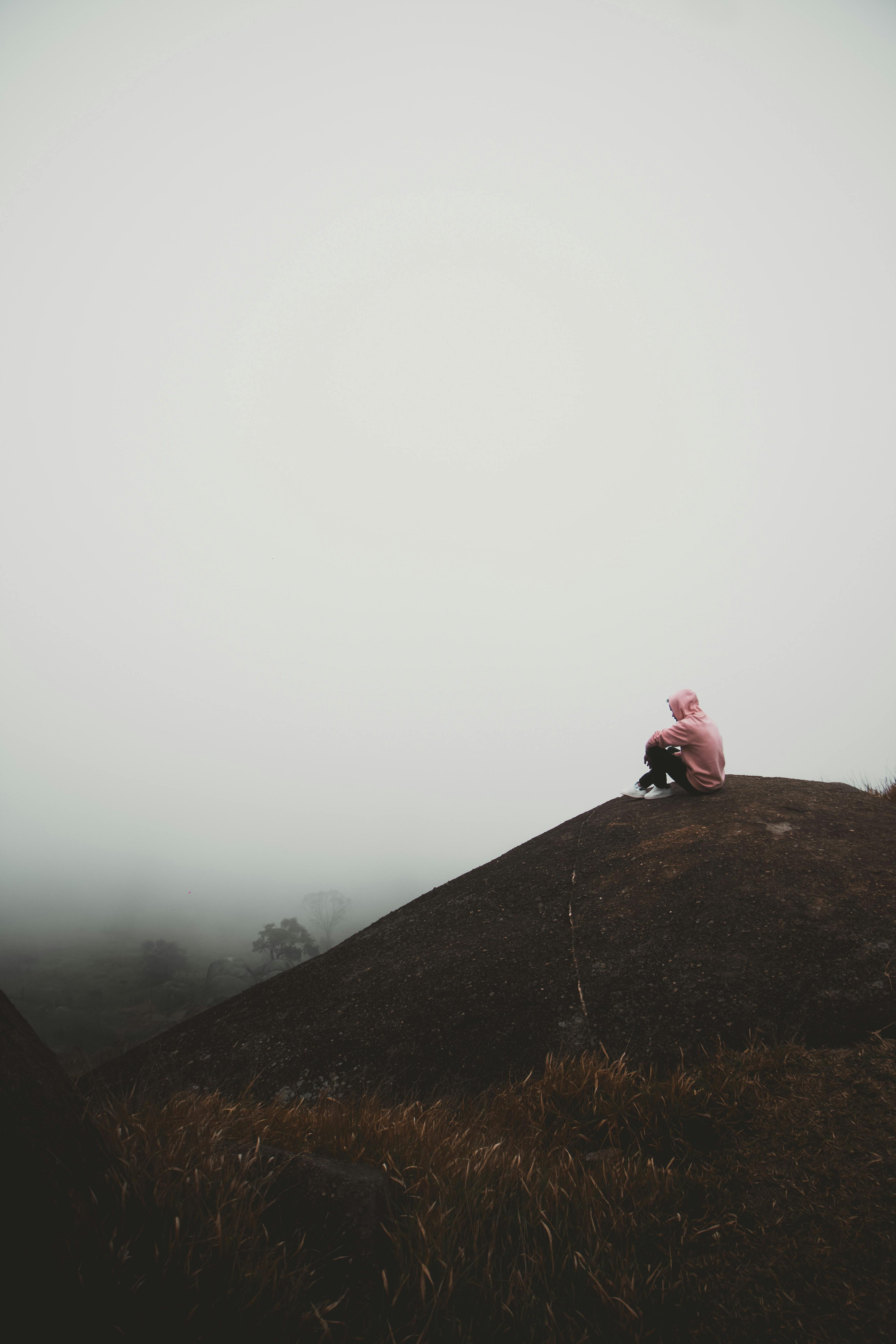Person Sitting on Mountain Peak in Fog · Free Stock Photo