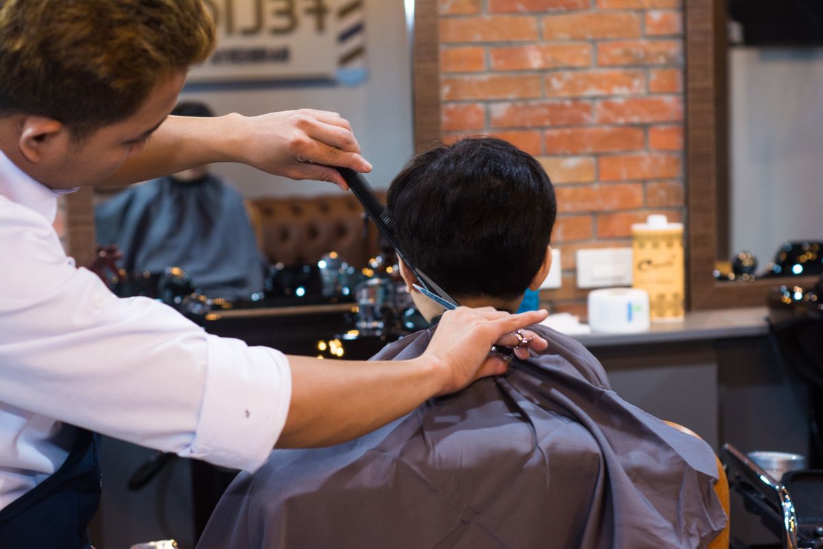 A barber giving a precise haircut to a client