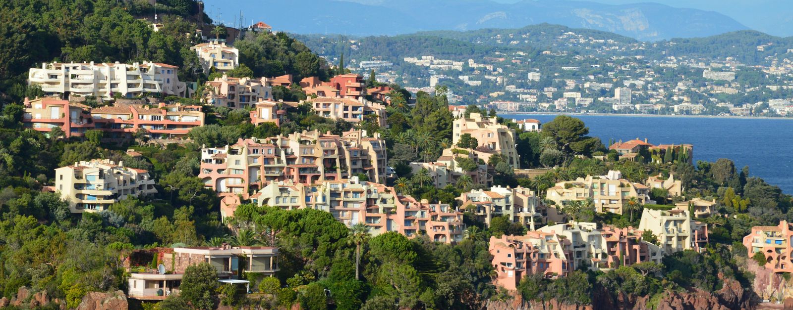 Picturesque hillside view of Theoule-sur-Mer with vibrant buildings by the sea.
