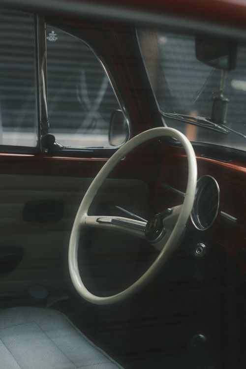 Free Close-up of a vintage car interior showcasing an elegant classic steering wheel. Stock Photo