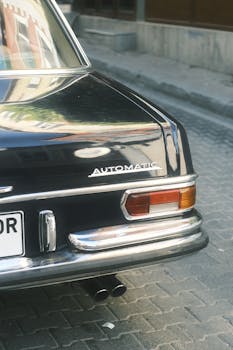Rear view of a vintage automatic car parked on an urban street, showcasing retro design.