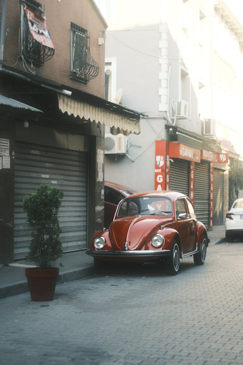 Red Volkswagen Beetle Parked on the Sidewalk