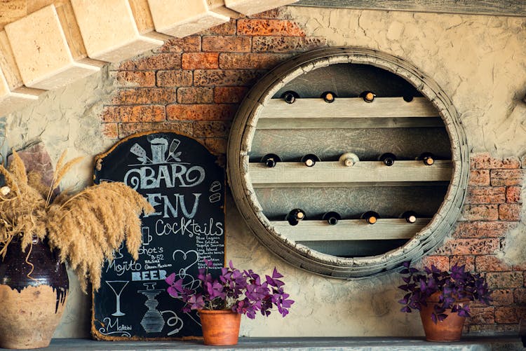 Wine Bottles On Shelf On Brick Wall