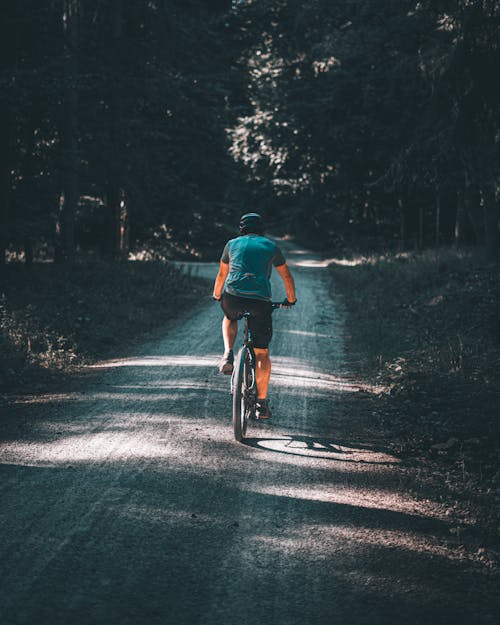 Man Riding a Bicycle on Dirt Road