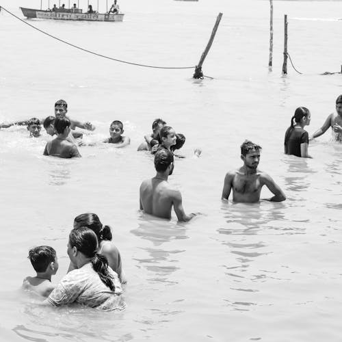 Grayscale Photo of People Swimming in the Sea