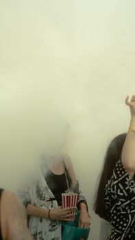 A mysterious party atmosphere in Istanbul with people dancing amidst thick fog and popcorn.