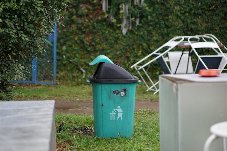 Black And Green Trash Bin On Grass Field 