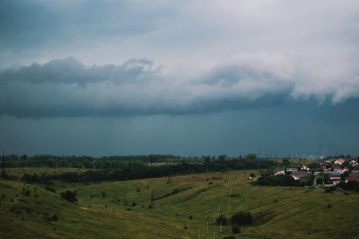 A sweeping view of rolling green hills under a dramatic cloudy sky, showcasing nature's beauty.