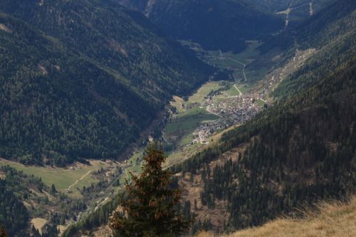 Free A stunning aerial view of a town nestled in a lush mountain valley surrounded by forests. Stock Photo