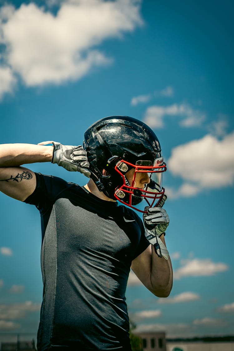 Photograph Of A Man Putting On A Helmet