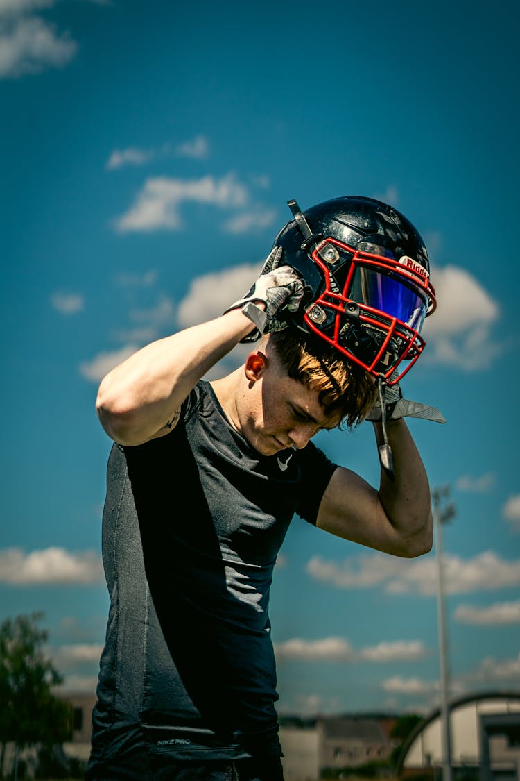 Photo Of A Man Putting On A Helmet