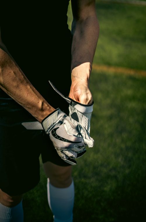 Free Close-up of a person wearing gloves on a sunny sports field Stock Photo