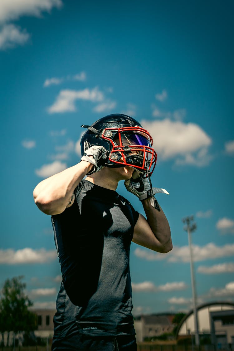 A Football Player Taking Off A Helmet 