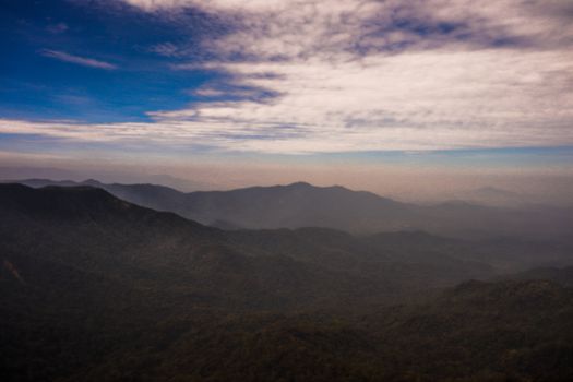 A stunning aerial shot of green mountains under a cloudy sky, showcasing natural beauty.
