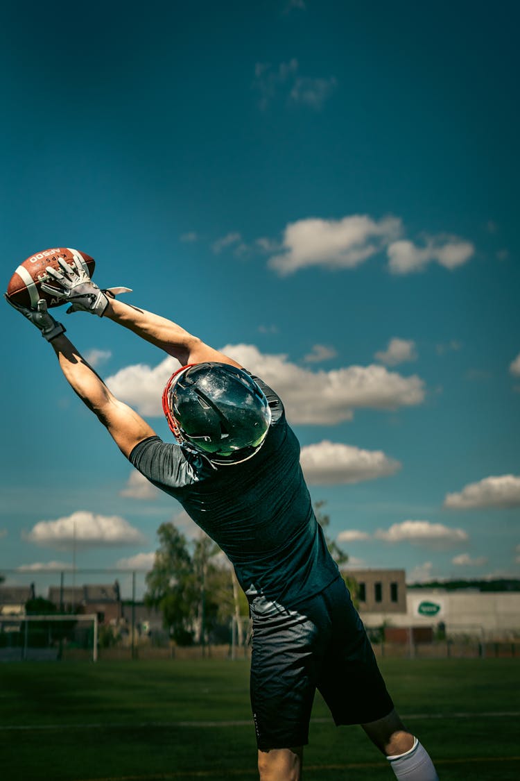 Football Player Catching A Ball