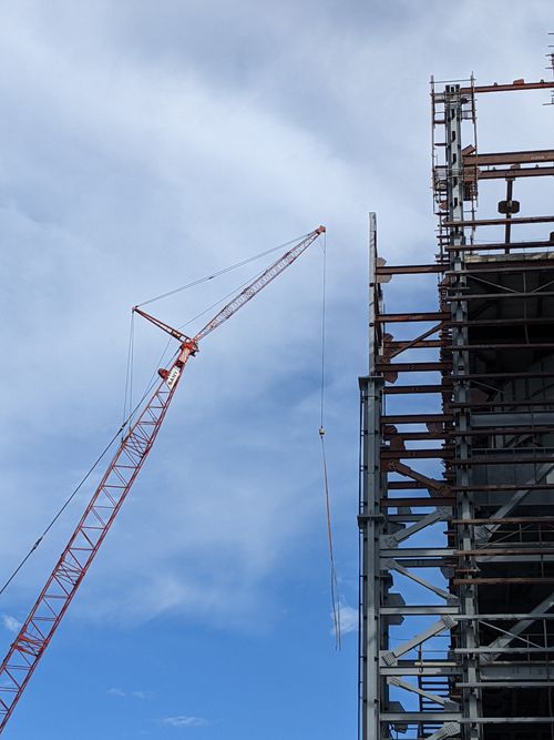 Free Tower crane at construction site in Bangladesh, displaying steel structure against clear blue sky. Stock Photo