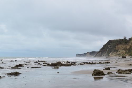 Free Explore the serene rocky shores of Jama, Ecuador with overcast skies and gentle waves. Stock Photo