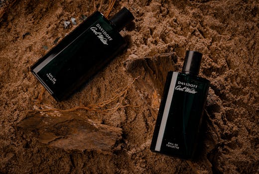 Close-up of elegant perfume bottles on sandy background, ideal for product photography.