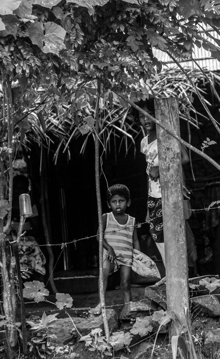 Black And White Photo Of Mother And Son Standing Behind Barbed 