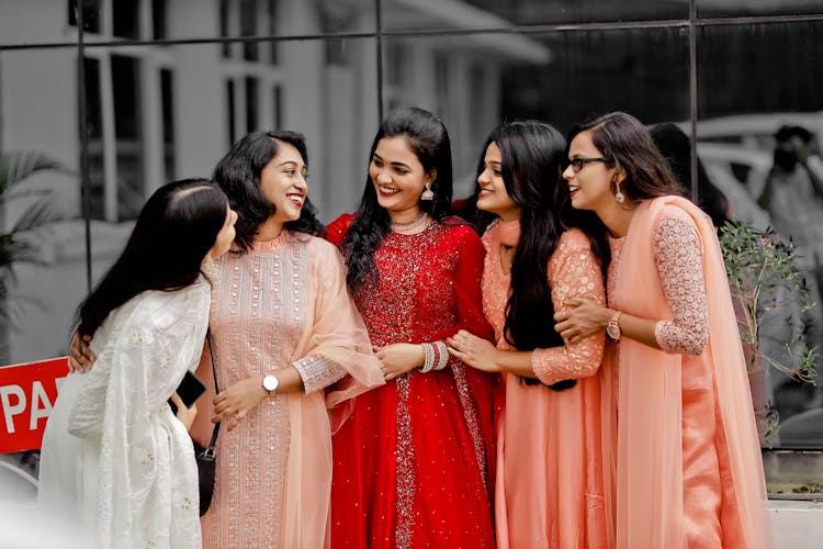 Group Of Smiling Women In Elegant Dresses