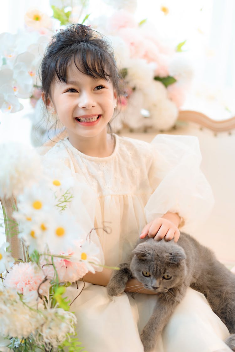 A Young Girl Holding A Cat 