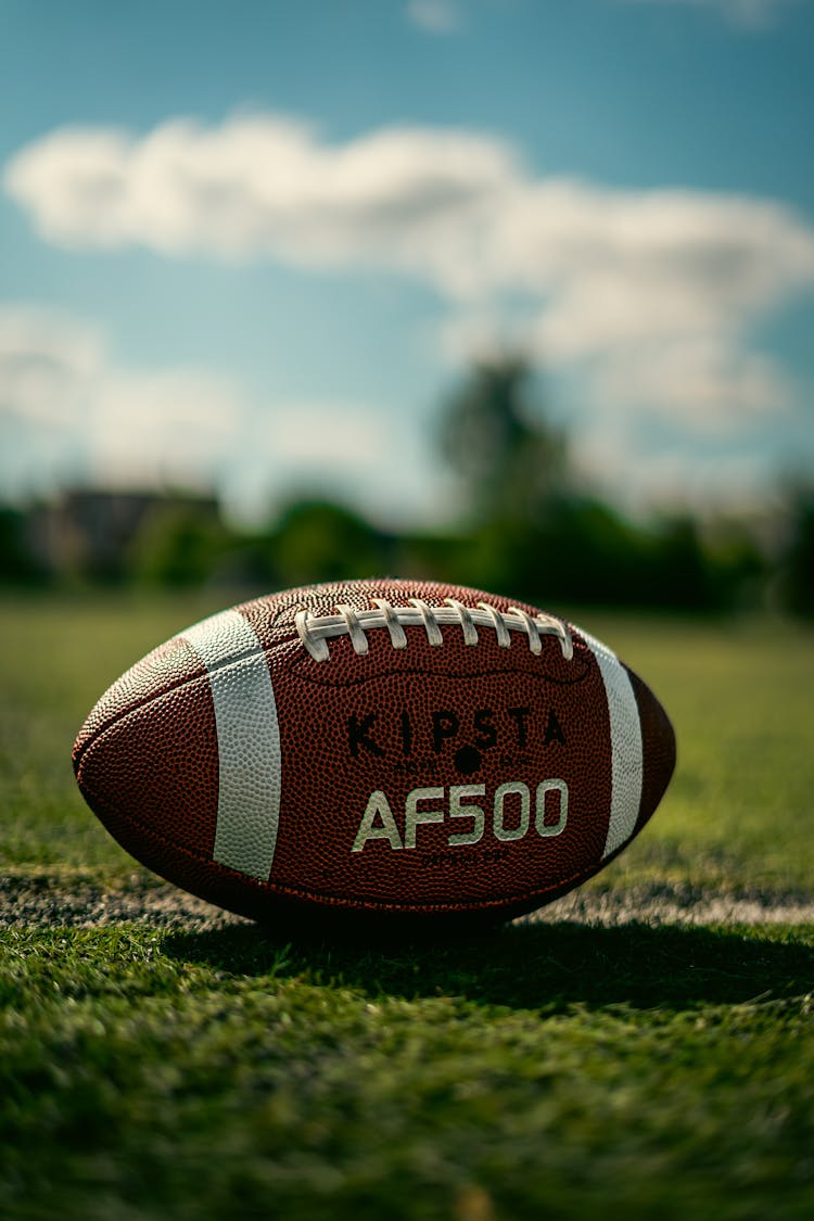 An Oval Football On Grass