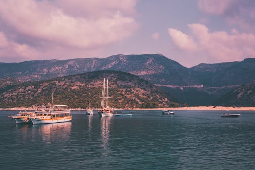 Scenic view of boats anchored in a tranquil bay with mountains in the backdrop.