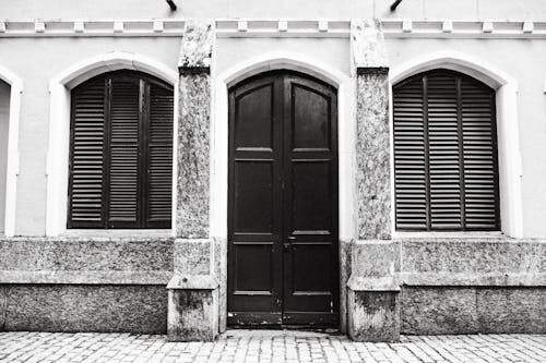 Grayscale Photo of Wooden Windows and Door