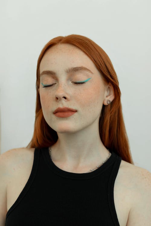 Portrait of a Young Beautiful Redhead Woman with Her Eyes Closed