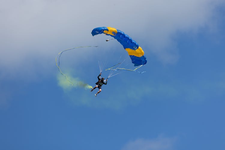 Man Paragliding In Blue Sky