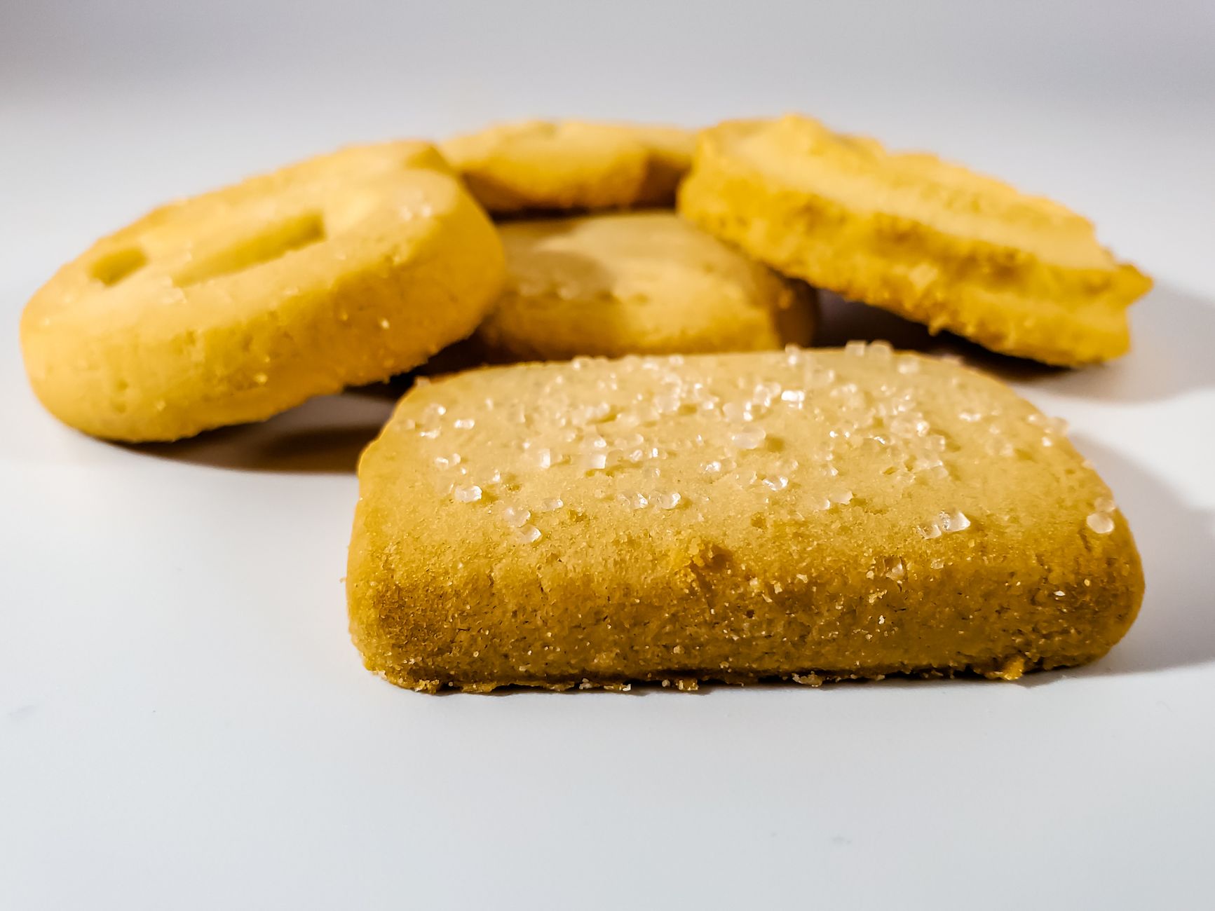 Close-up of sugar-dusted shortbread biscuits on a white surface