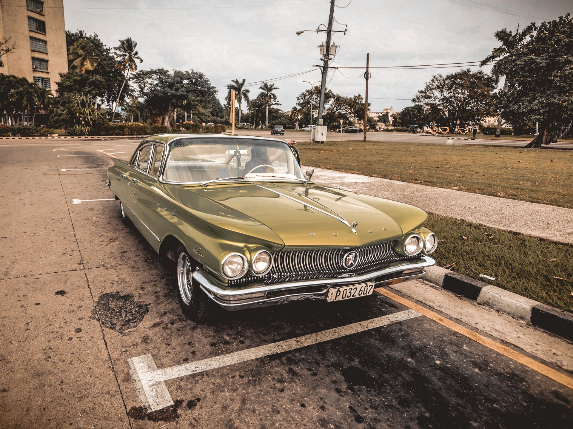 Classic green Buick car parked on a city street, showcasing vintage flair and automotive elegance.