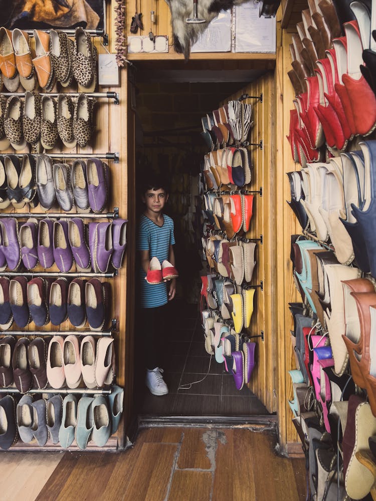 A Boy Holding Red Shoes