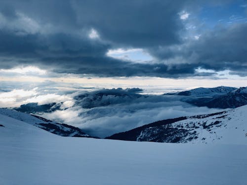 Snow Covered Mountains Under Cloudy Sky