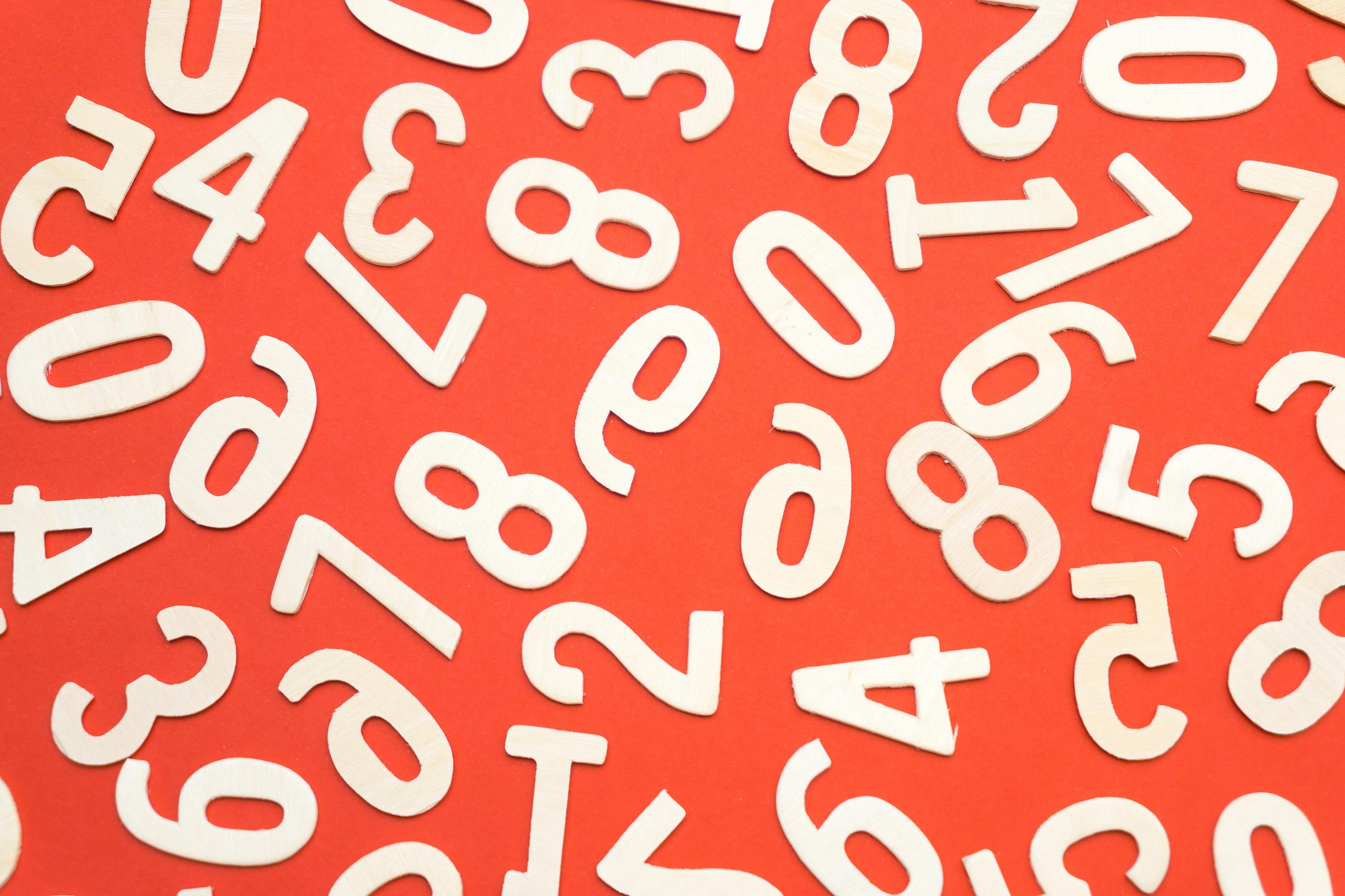 White numbers scattered randomly on a bright red background, showing the numeric characters banned from most baby names.