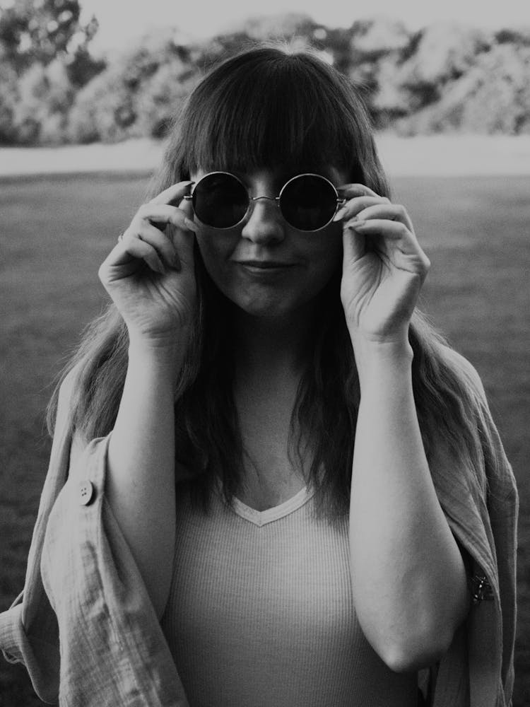 Woman Putting On Sunglasses 