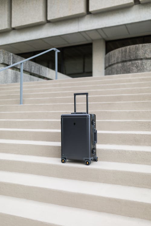 Free A carry-on suitcase sits on minimal steps Stock Photo