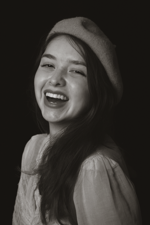 Free Charming monochrome portrait of a woman laughing joyfully in a studio setting. Stock Photo