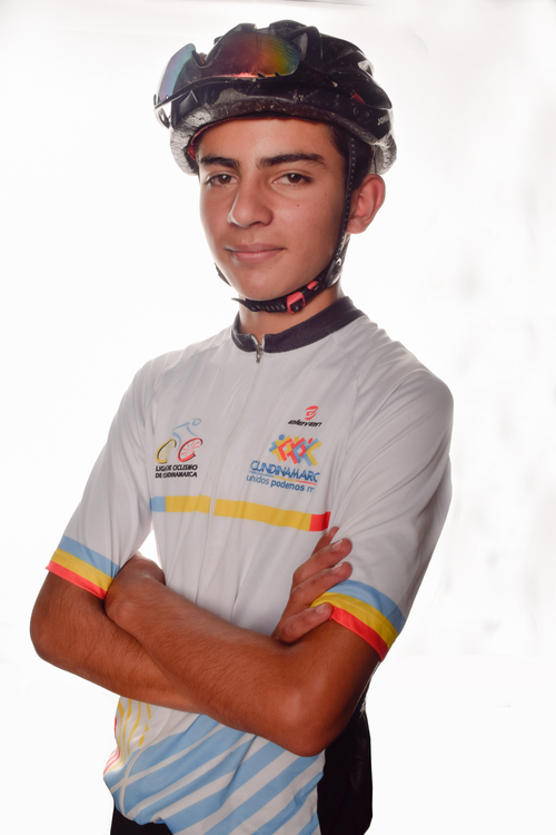 Free Young male cyclist wearing a helmet and jersey, posing confidently with arms crossed. Stock Photo