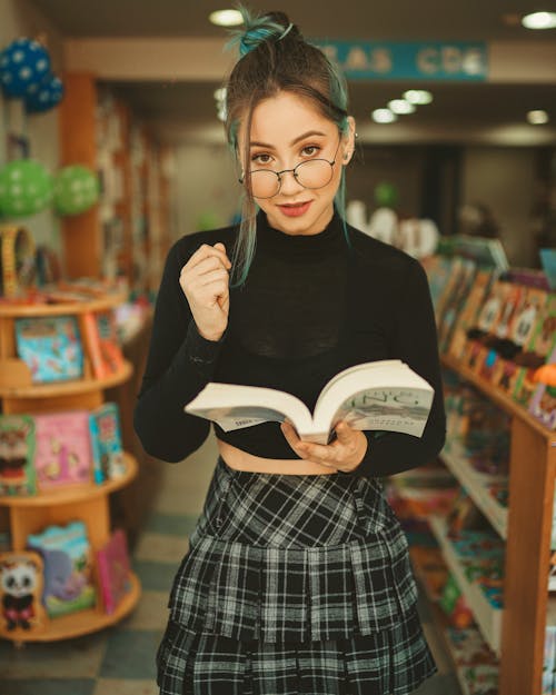 A Woman Wearing Eyeglasses While Holding a Book
