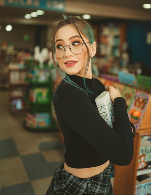 A Woman in Black Long Sleeves Holding a Book