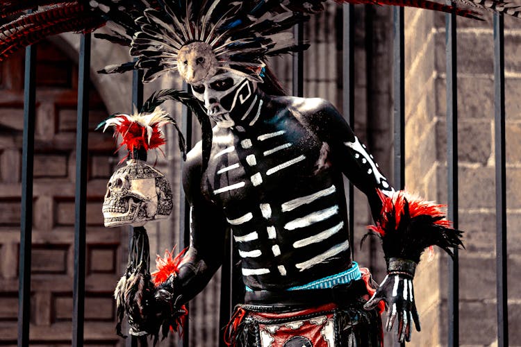 Man With A Mexican Dead Face Paint Holding A Skull