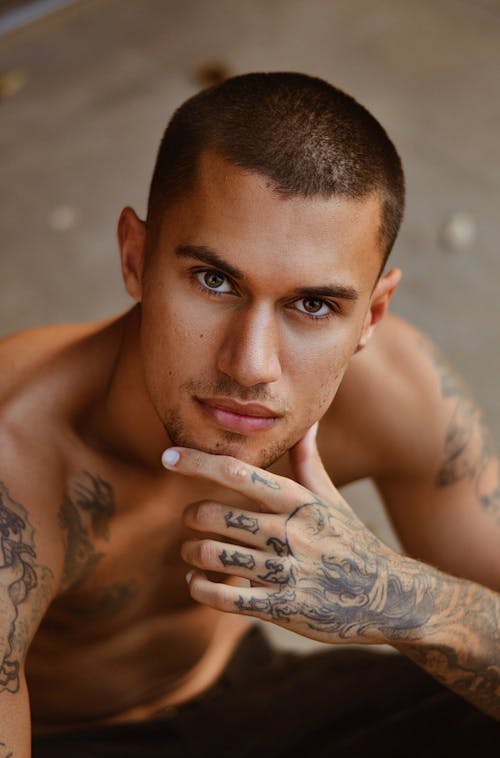 Portrait of Young Man with Tattoos on Hands and Arms 