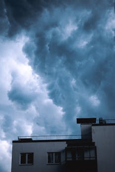 A modern building facade against a dramatic cloudy sky, capturing urban architecture