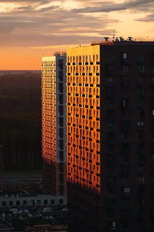 Free Urban high-rise buildings illuminated by golden sunset glow, showcasing city architecture. Stock Photo