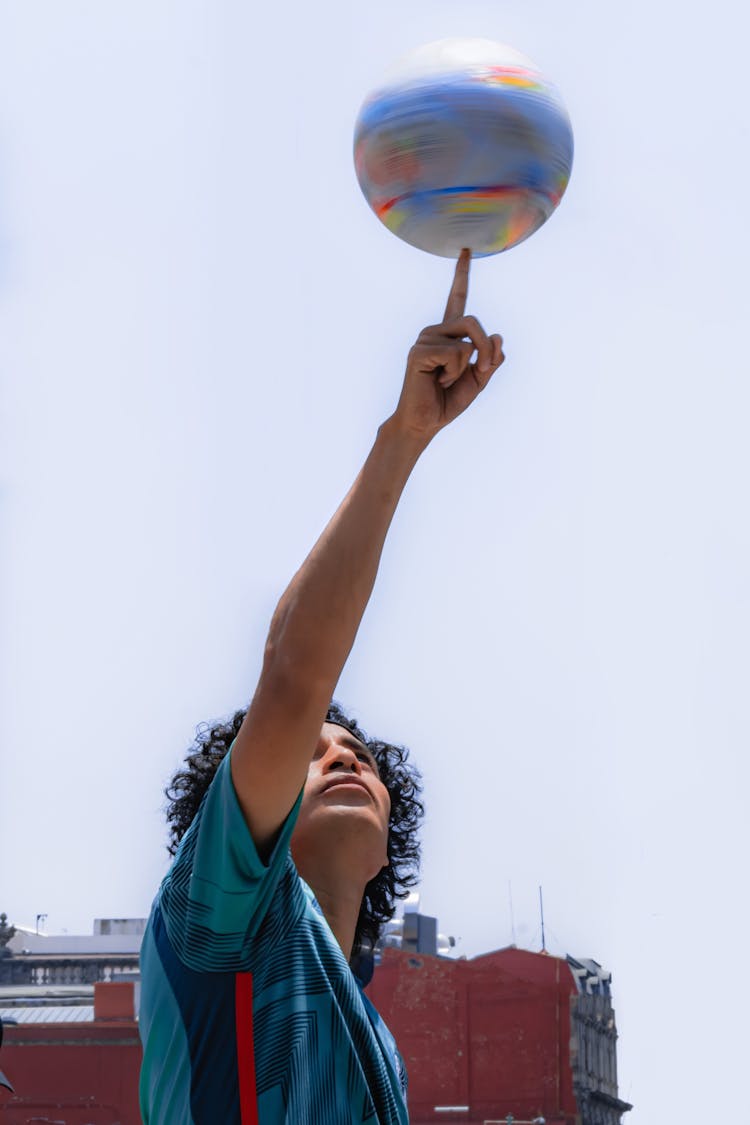 A Man Spinning The Ball Using Finger