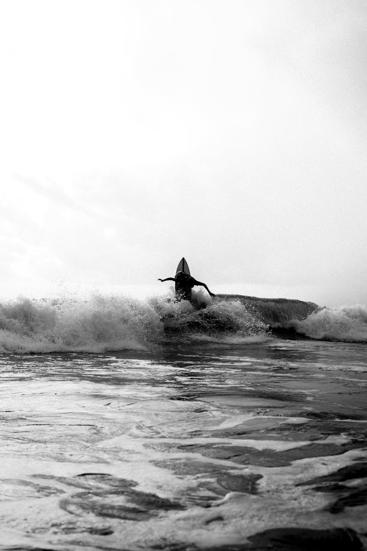 Black And White Photo Of Man Surfing On The Sea